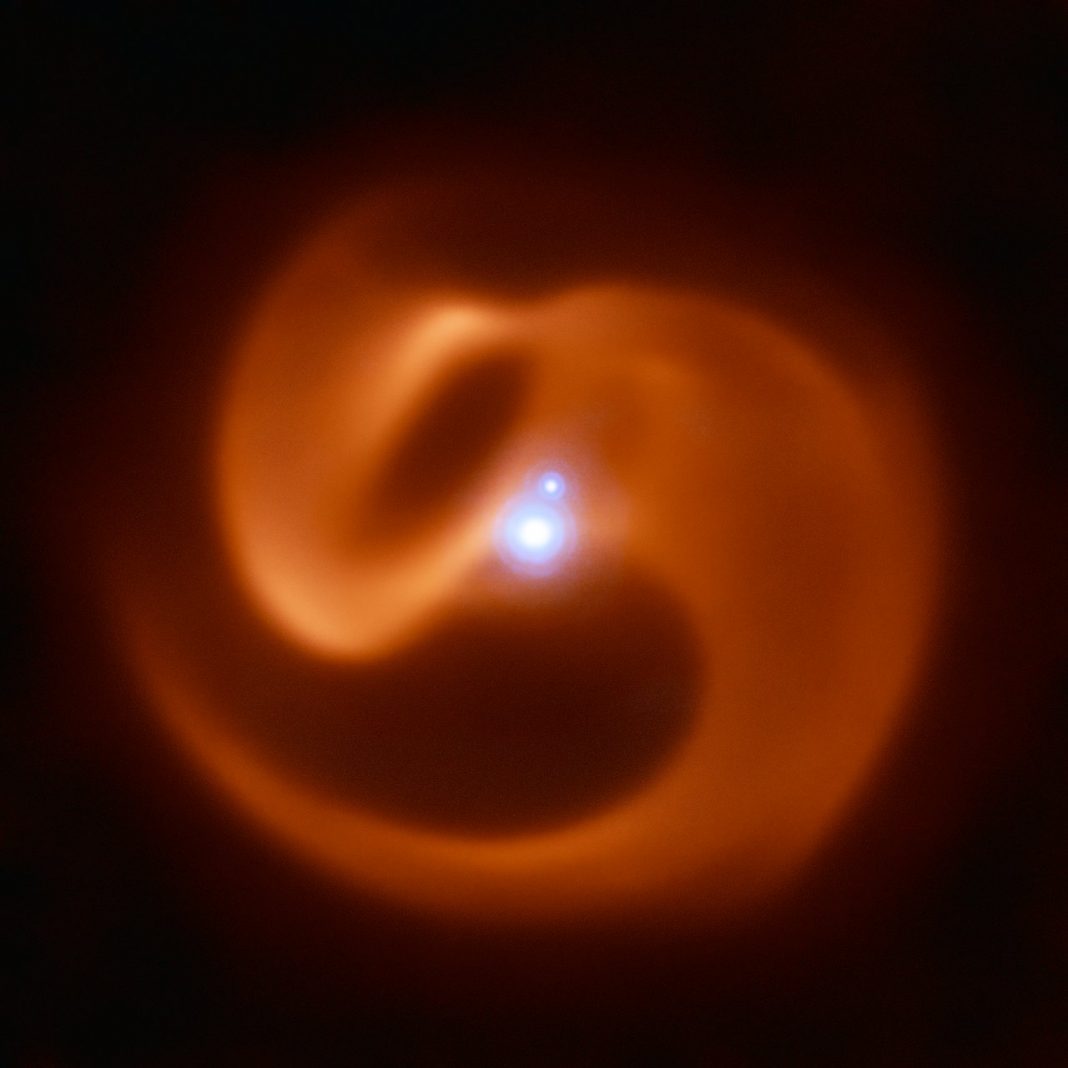 Enormous Triple Galaxy Produces this Unusual Swirling Pinwheel of Dust. And it Might be the Website of a Gamma Ray Burst